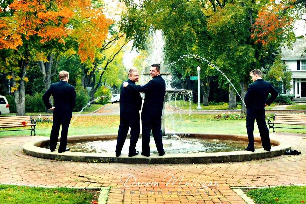 groomsmen pretend to pee into fountain in their wedding photos