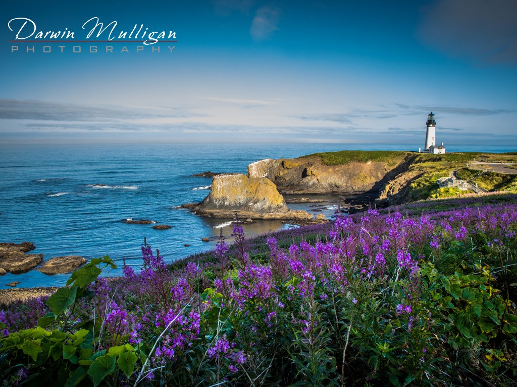 Early morning light and flowers light up Yaquina Head Lighthouse on the Oregon Coast
